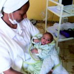 Una delle suore dell'Health centre Ashirà con un piccolo paziente