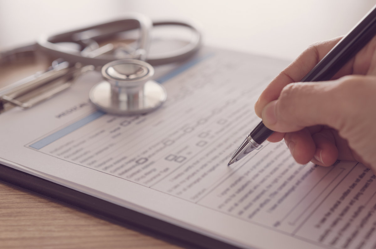 closeup pen in hand's doctor notes data on medical document.